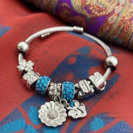 Silver Charm Bracelet with Blue Beads, Daisy Pendant, and Butterfly Charms