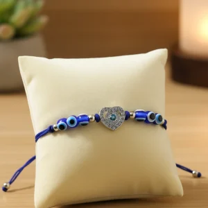 Blue evil eye protection bracelet with heart charm on wooden background – premium adjustable bracelet for women.