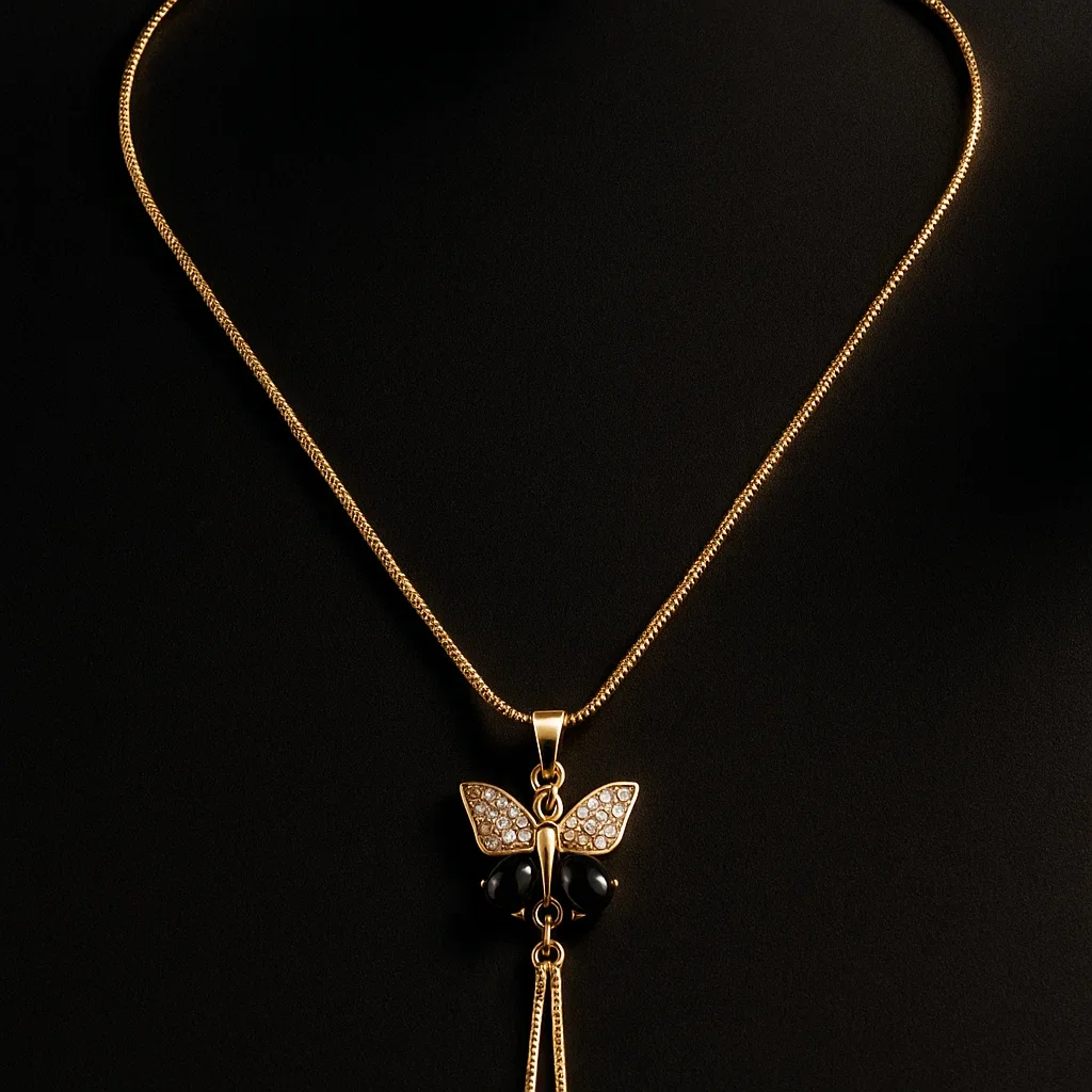 Gold butterfly pendant with adjustable chain and ball sliders on white marble surface flat lay