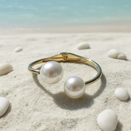 Minimal gold-plated pearl open cuff bracelet worn on wrist at the beach – Zivaara Jewelry