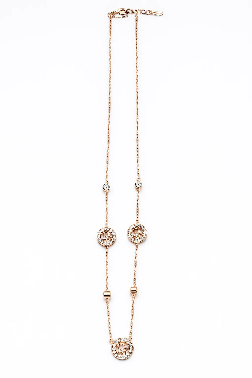 Full length rose gold necklace with letter D crystal pendants and adjustable clasp on white background flat lay