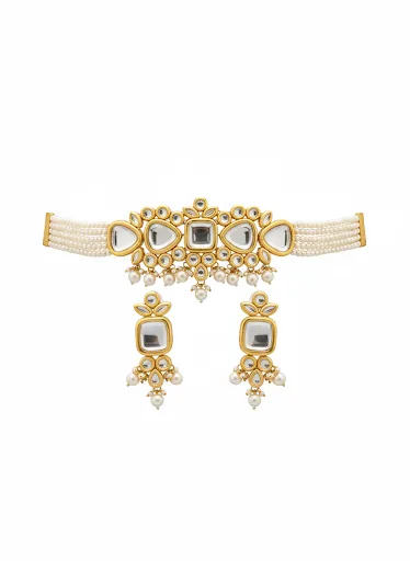 Gold-plated Kundan necklace with pearl drops and matching earrings on black jewelry display against teal silk background